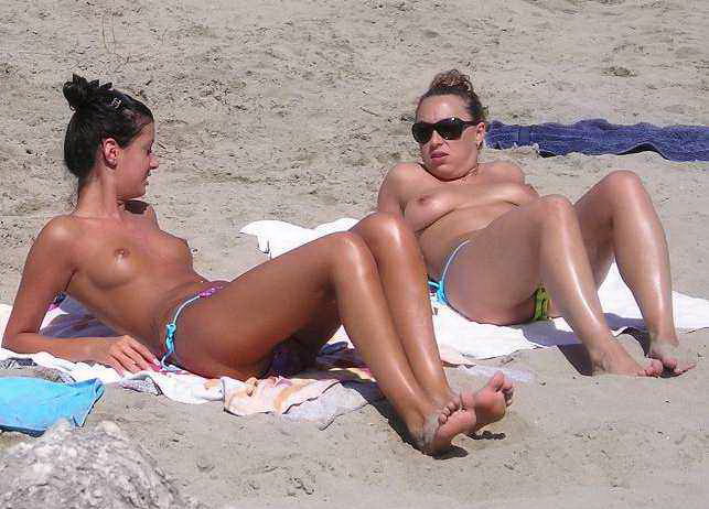 Женщины на пляже как обнаженные, так и раздевающиеся